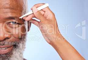 Fine, Im ready. a mature man having his eyebrow tweezed by an unrecognizable woman against a blue background.