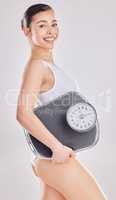 Consider your discipline as a down-payment on a healthy and active life down the line. a woman holding a weight scale while posing against a studio background.