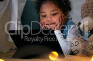 Everywhere, we learn only from those we love. an adorable little girl using a digital tablet at night.