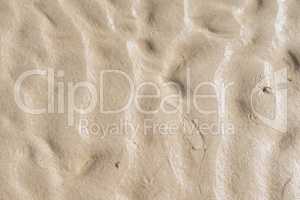 Closeup of textured brown surface with copyspace. Details and patterns of sand or ground with copyspace. Zoom in on shapes in the sand, texture and rough surface level flooring, abstract background