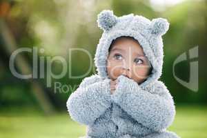 When is somebody coming to play with me. an adorable baby boy wearing a furry jacket with bear ears outdoors.