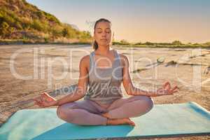 Full length yoga woman meditating with legs crossed for outdoor practice in remote nature. Mixed race mindful active person sitting alone and balancing for mental health. Young hispanic serene and zen