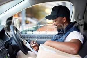 I have one more delivery to do for the day. young man delivering a package while sitting in a vehicle.