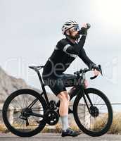 Staying hydrated. Full length shot of a handsome mature man taking a water break while cycling outdoors.