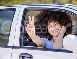 Im outta here. a beautiful young woman enjoying an adventurous ride in a car.