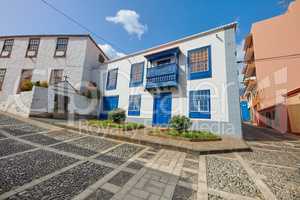 Colorful homes with a traditional design in the city of Santa Cruz de La Palma. Street in small old town or village with bright and vibrant residential buildings on a cloudy summer day