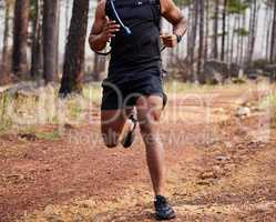 Hispanic unrecognizable fit male athlete running in a forest outside in nature. Exercise is good for health and wellbeing. Jogging in a park alone during the day