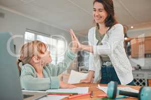 Smiling young mother helping daughter with homework during quarantine, high fiving and motivating her. Happy mother supporting, celebrating her daughters success in her school work