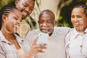 Dad takes selfies until he finds the perfect one. a woman showing her parents something on her cellphone.