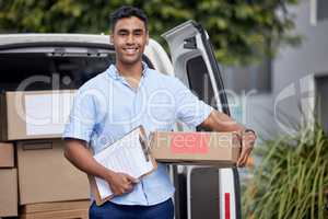 Your stop is next on my list. Portrait of a young delivery man loading boxes from a van.