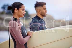 Everything changes when your board touches the water. a young couple surfing together at the beach.