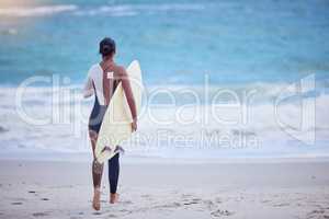 Stay wild, ocean child. Rearview shot of a young woman running towards the sea with a surfboard.