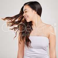 When she flips her hair, the world sees her shine. Studio shot of a young woman with beautiful long hair.