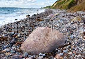 Coast of Kattegat - Helgenaes, Denmark. Ocean waves washing onto empty beach shore stones. Calm peaceful paradise of summer seascape and sky for relaxing fun holiday abroad or travel vacation