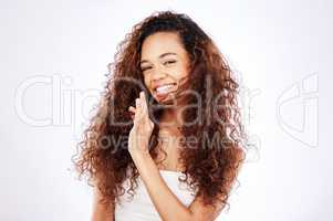 Reason to smile look at these kinks. Portrait of a beautiful young woman showing off her natural curly hair against a white background.