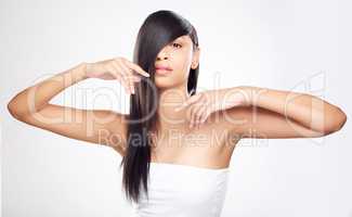 Be sleek not sly. a young woman posing against a white background with healthy looking hair.