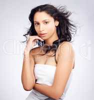 Dont let my good looks glow you away. a young woman posing against a white background with healthy looking hair.
