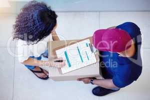 Its all yours once you sign for it. High angle shot of a customer signing for her delivery from the courier.
