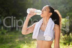 Nothing better than water. a young woman drinking water during a workout.