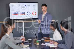 Meetings help keep them all on the same page. a group of businesspeople having a meeting in a boardroom at work.