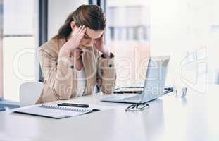 I need a miracle to make it through today. a young businesswoman looking stressed out while working on a computer in an office.