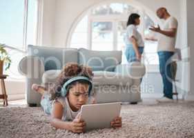 Fighting around children is never okay. a young girl using a digital tablet while her parents argue.