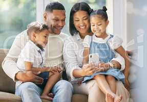 A family is a circle of strength, love, and laughter. a family using a smart phone at home.