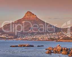 Copy space with scenic landscape view of a coastal town along Lions Head mountain in Cape Town, South Africa against a twilight sky background. Panoramic of the sea with an iconic landmark at sunset