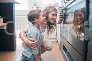 Most recently, I learned another hobby baking. a little boy and his mother sitting in front of the oven.