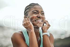 Let the music be your motivation. a young woman listening to music while on a run.