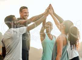 Cheers to having great workout partners. a group of friends high fiving one another before a workout.