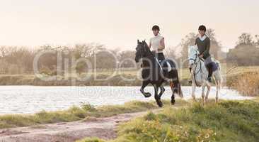 Riding is a well known stress relieve. two young women out horseback riding together.