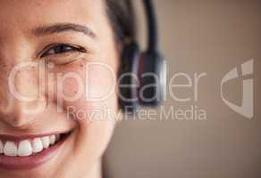 Closeup portrait of young mixed race female call center agent wearing headset. Face of smiling and friendly customer service operator answering calls. Helpdesk and hotline