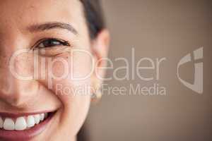 Face of beautiful mixed race woman smiling with white teeth. Portrait of a womans face with brown eyes and freckles posing with copy-space. Dental health and oral hygiene