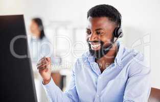One happy young african american male call centre telemarketing agent cheering with joy and punching the air with fists while working in an office. Excited businessman celebrating successful sales and reaching targets to win