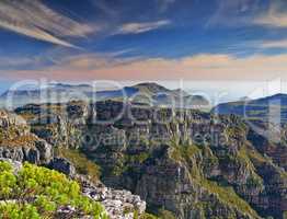 Copy space with scenic landscape at the peak of Table Mountain in Cape Town with cloudy blue sky background. Breathtaking and magnificent views of the beauty in nature after a hike up a rocky region