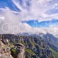 Thick clouds forming on the top of Table Mountain in Cape Town with copyspace. Rocky terrain on a sunny day with cloudy shadows, peaceful nature in harmony with soothing views of plants and landscape
