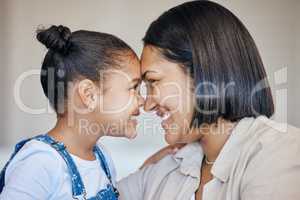 Adorable little girl and mom touching foreheads. Closeup of happy mother and daughter looking into each others eyes. Mixed race family expressing love, enjoying tender moment together at home