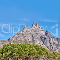 Landscape view and blue sky with copy space of Table Mountain in Western Cape, South Africa. Steep scenic famous hiking and trekking terrain with trees growing around in. Cable car transport to peak