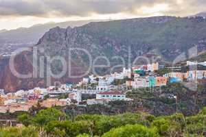 Historical spanish or colonial architecture in tropical village in tourism destination. City and mountain view of residential houses or buildings in serene hill valley in Santa Cruz, La Palma, Spain.