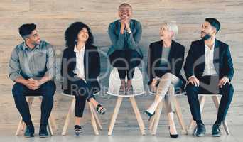 Nothing worthwhile comes easily. Shot of a group of businesspeople sitting in a row in an office at work.