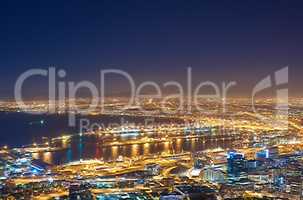 Aerial view of the night cityscape of Cape Town, South Africa. Wide angle of beautiful scenic view city lights in the evening. High angle view from the signal hill in the darkness in a coastal town.