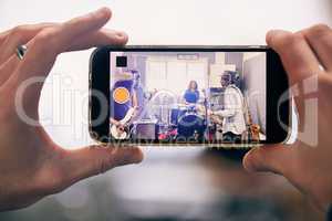 Experience life from a different perspective. an unrecognizable person recording a band practicing at home.