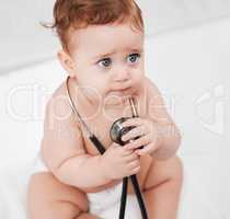 Erm, lady doctor will this hurt. an adorable little baby boy hold a stethoscope in a clinic during his checkup.