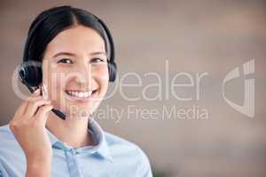 Closeup of smiling mixed race call centre agent smiling while wearing headset. Female customer service representative using headset and consulting clients online