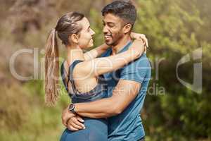 Affectionate young interracial couple taking a break from exercise and run outdoors. Loving man and woman hugging while motivating each other towards better health and fitness
