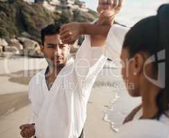 Now counter. two young martial artists practicing karate on the beach.
