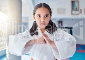 I pack a mean punch. a cute little girl practicing karate in a studio.