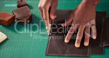 Working with his hands. High angle shot of an unrecognizable male designer working with leather in his design studio.