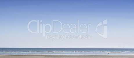 Copy space at the sea with a clear blue sky background above the horizon. Panoramic of calm ocean waters across a beach shore. Peaceful scenic coastal landscape for a relaxing and zen summer getaway
